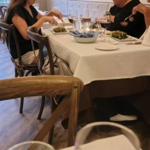 A couple toasting with red wine, enjoying a date night at Pepe & Sale in Stuart, FL.