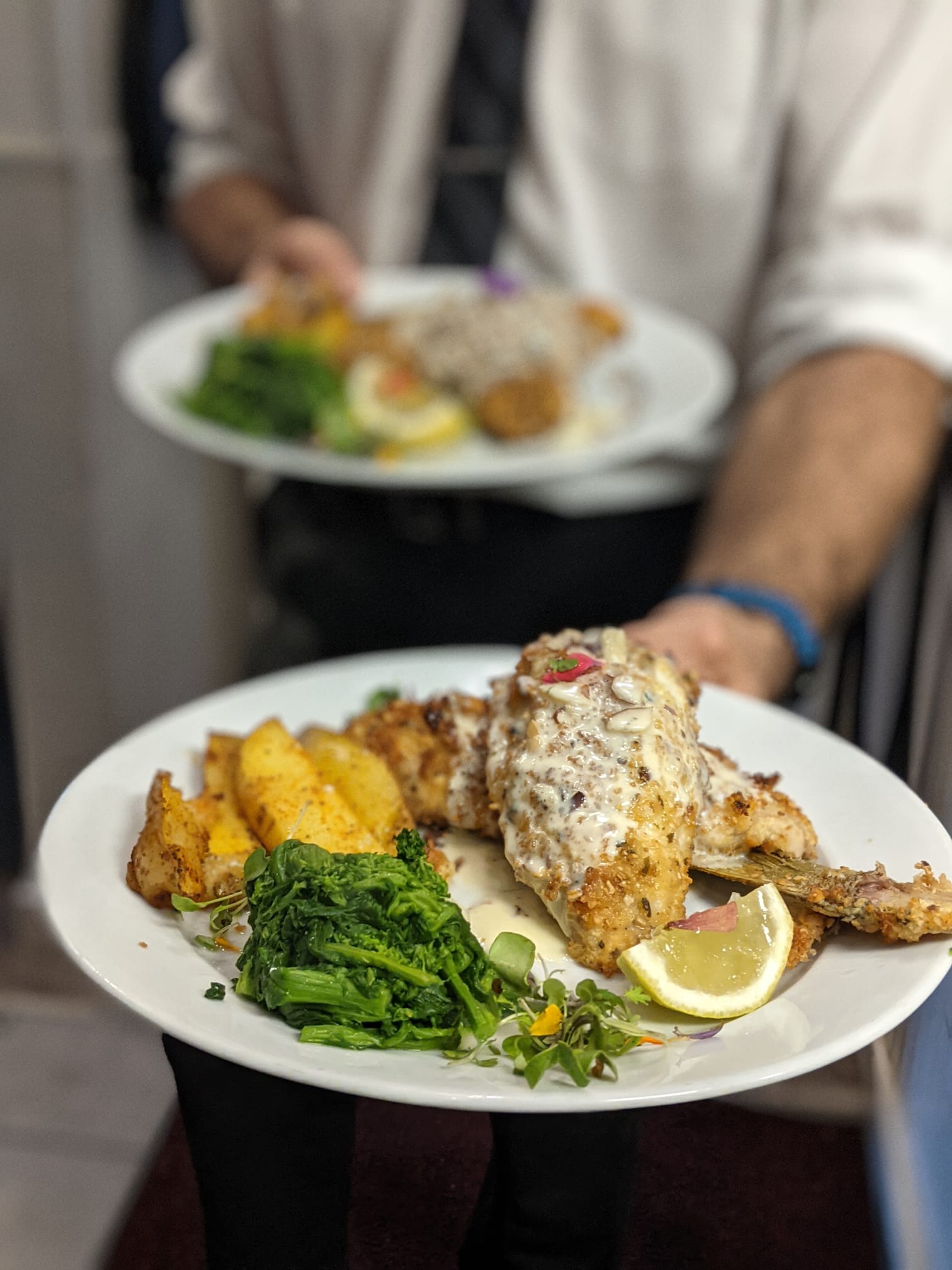A server at Pepe & Sale providing meticulous, fine dining service to a guest.