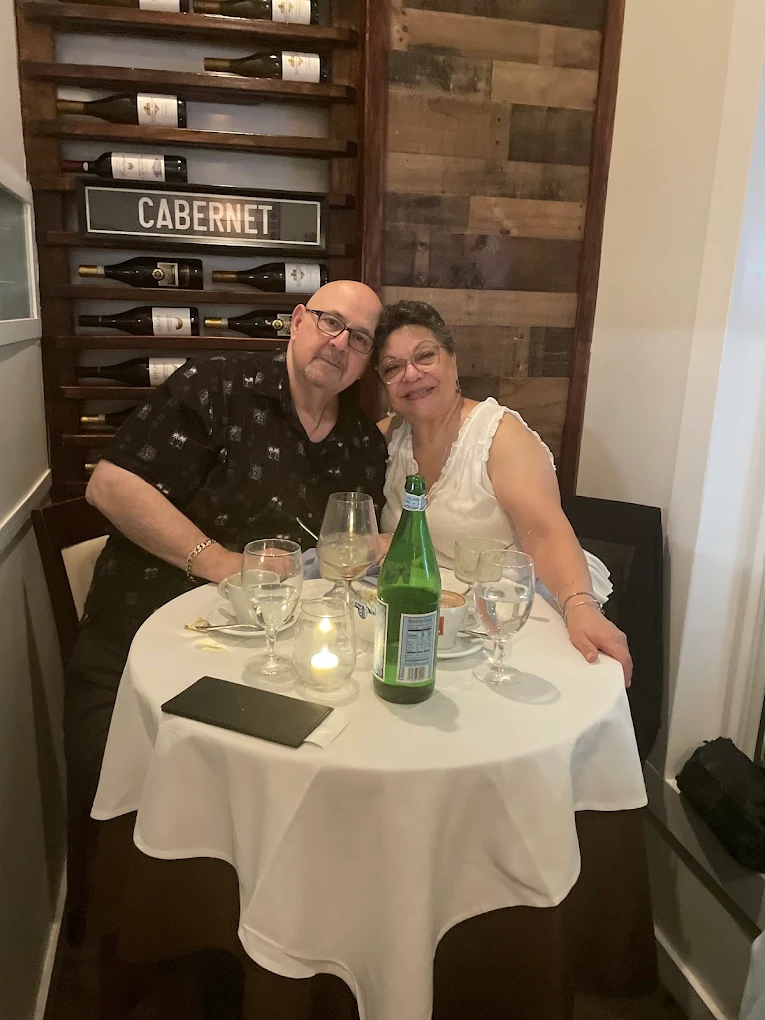 A couple toasting with red wine at Pepe & Sale, one of the most romantic restaurants in Stuart, FL.